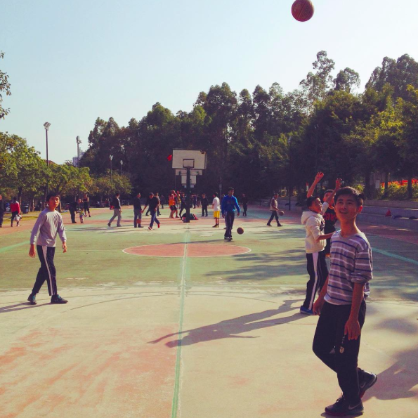 Китайские дети радуются появлению иностранца на спортивной площадке.